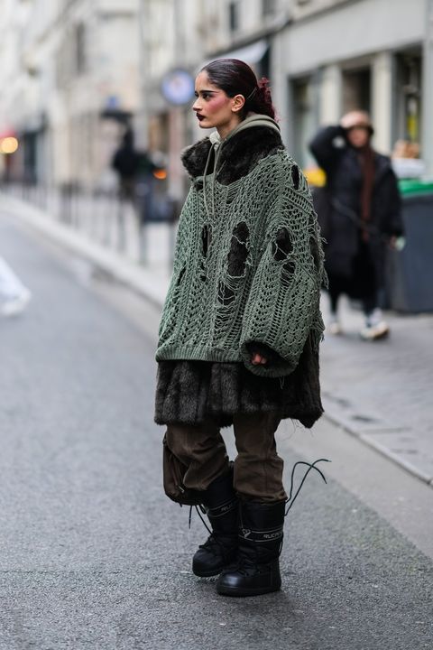 paris, france   january 23 a guest wears a khaki hoodie sweater, a black oversized fur long coat, a khaki ripped oversized pullover, brown denim jeans pants, a brown handbag, black nylon knees snow boots, outside wooyoungmi, during paris fashion week   menswear fw 2022 2023, on january 23, 2022 in paris, france photo by edward berthelotgetty images