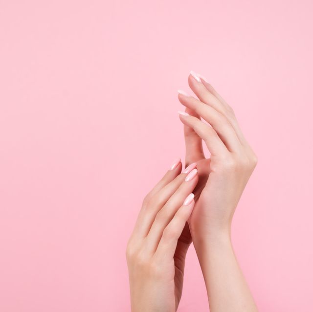 tender hands with perfect blue and pink manicure on trendy pastel pink background place for text