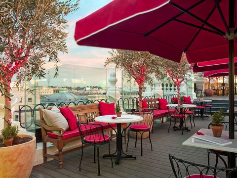 vista de la terraza de este hotel de madrid con sombrillas y sillas en color rojo