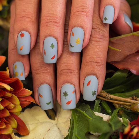 grayish blue painted nails with falling leaves in all colors scattered about