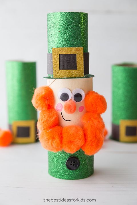 leprechaun made out of a toilet paper roll with googly eyes, green glittery hat and shirt, and orange pom poms for the beard