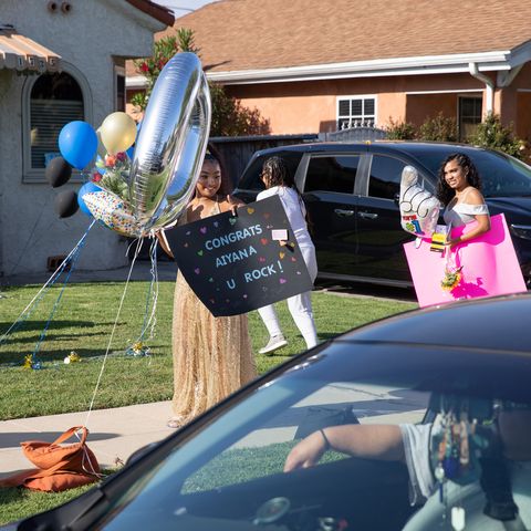 virtual graduation ideas graduates in dresses holding sign with car going by