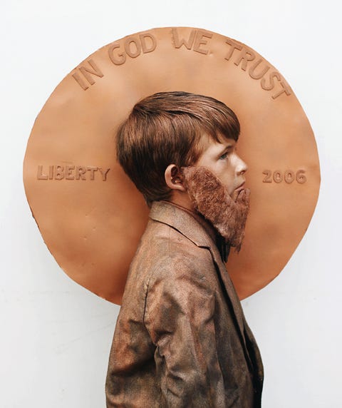 boy with fake beard and brown-painted suit standing in profile in front of big fake penny boy with fake beard and brown painted suit standing in profile in front of big fake penny