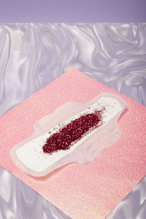a period pad with glitter on a pink glitter background