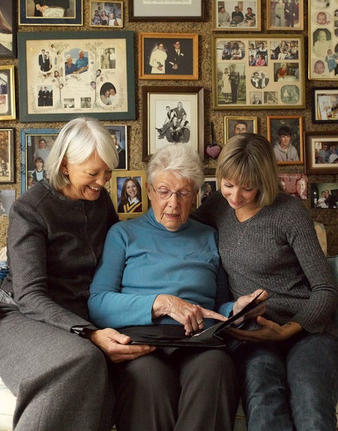 three older women looking at a family photo album