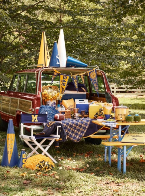 woody wagoneer styled in yellow and blue for a football tailgate on lawn on autumn day