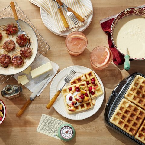 a table with sausage and waffles and grapefruit drinks