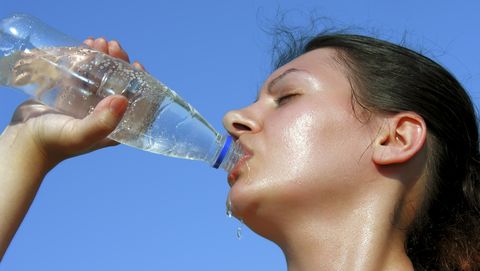 bezwete vrouw drinkt water uit flesje