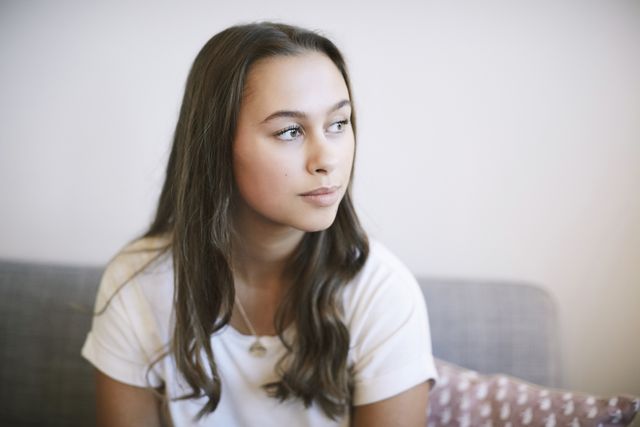 thoughtful teenage girl sitting at wellness center