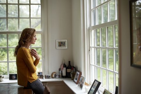 thoughtful woman having coffee in cottage