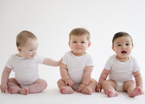 Three babies sitting on floor