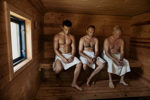 three men sitting in sauna with heads bowed