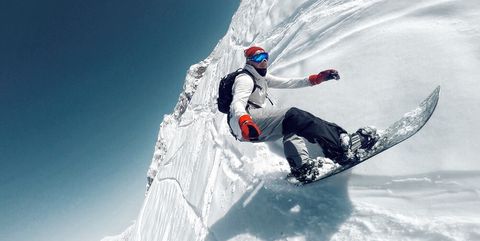 Tilt Image Of Man Snowboarding Against Clear Sky