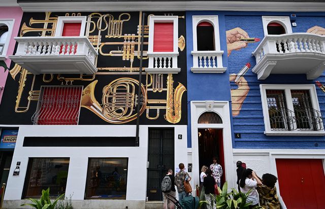 visitors view houses decorated by italian artist maurizio cattelan, as part of a redecoration of houses in balzaretti street with graphics inspired by the toiletpaper magazine, on june 8, 2022 during the fuorisalone 2022 design and furniture fair in milan   restricted to editorial use   mandatory mention of the artist upon publication   to illustrate the event as specified in the caption photo by miguel medina  afp  restricted to editorial use   mandatory mention of the artist upon publication   to illustrate the event as specified in the caption  restricted to editorial use   mandatory mention of the artist upon publication   to illustrate the event as specified in the caption photo by miguel medinaafp via getty images
