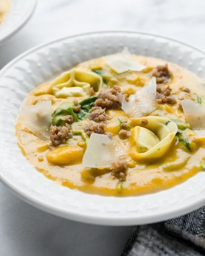 butternut squash sausage and tortelloni soup in white bowl