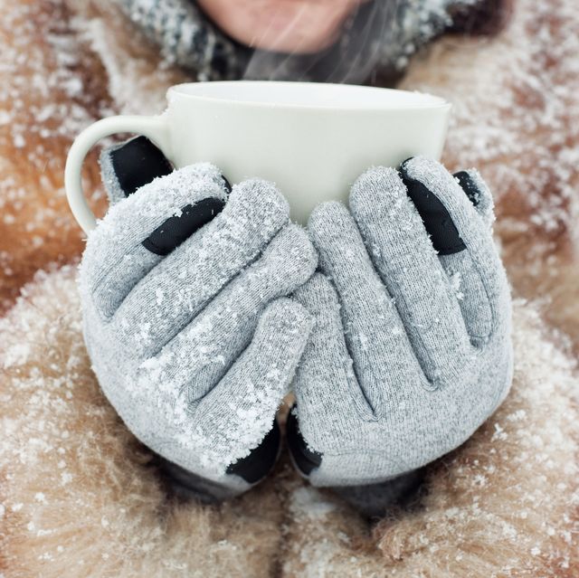 person holding mug in touchscreen gloves
