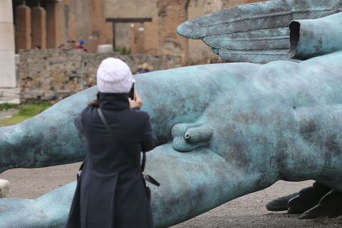 A tourist while taking pictures of the penis of one of the...