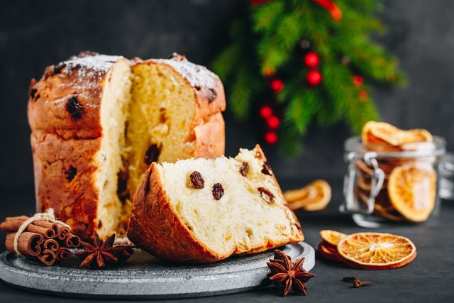 traditional christmas panettone cake with dried fruits on dark stone background