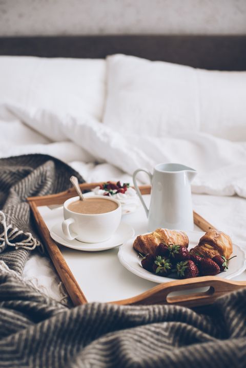 traditional romantic breakfast in bed in white and beige bedroom