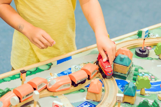 kid playing with train table