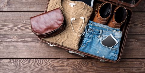 Travel preparations concept with open suitcase and woman's casual clothes