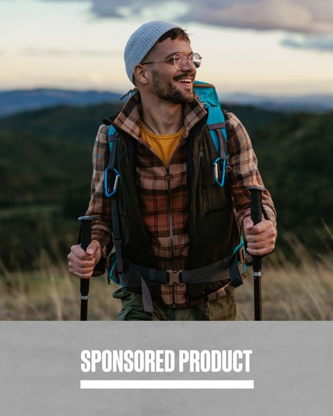 sponsored product man hiking in grassy field using hiking poles covered by world nomads insurance