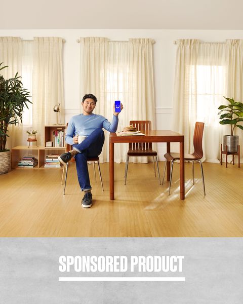 sponsored product man sitting down at dining table holding phone with visible app