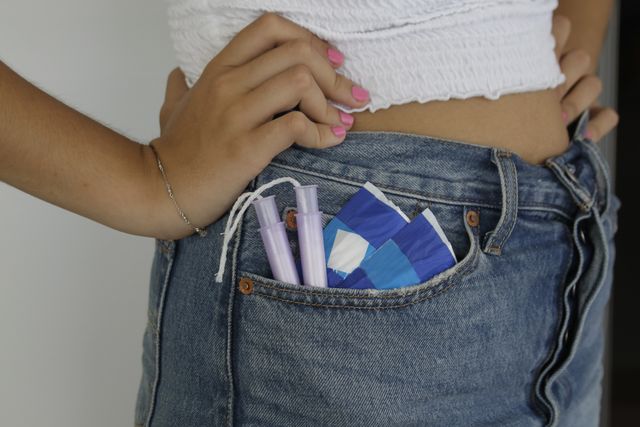 woman with sanitary pads and tampons in pocket