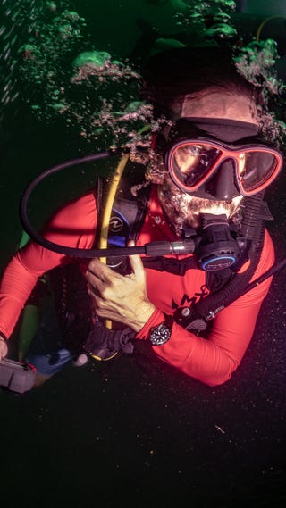 diver underwater wearing orange shirt