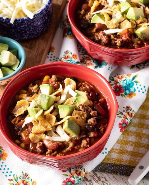 slow cooker turkey chili with avocado and chips in red bowls