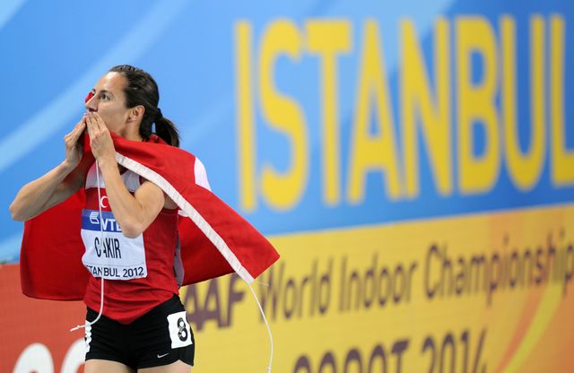 la atleta turca asli cakir celebra su éxito en el mundial indoor de atletismo de estambul 2012 con la bandera turca anudada al cuello y lanzando besos a la grada