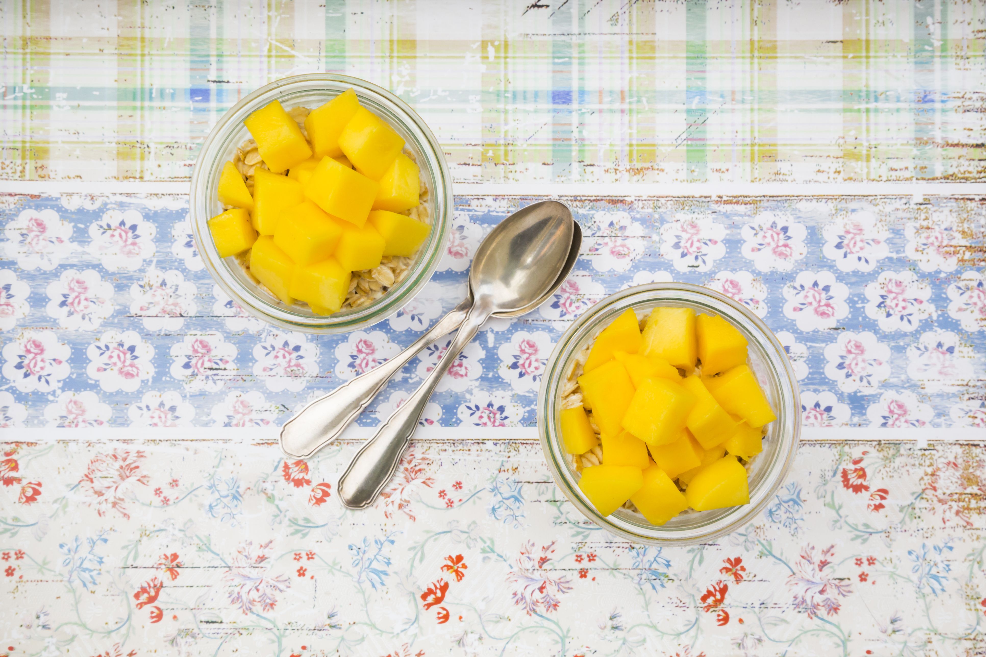 Two glasses of overnight oats with diced mango