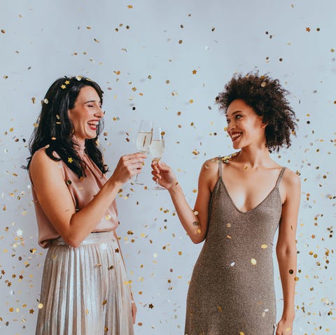 Two Happy Women Celebrating New Year's Eve With a Champagne Toast Under Confetti two happy women celebrating new year's eve with a champagne toast under confetti