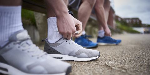 Two males tying their shoes preparing for a run