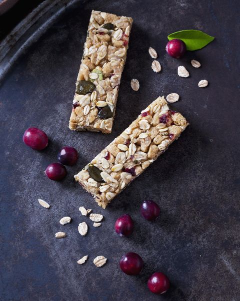 two muesli bars with cranberries on dark background