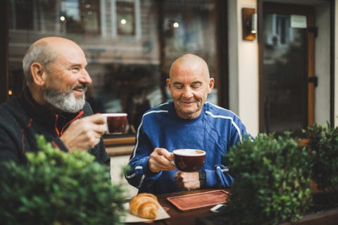 Two old age senior friends drinking coffee in cafe on outside terrace. Laughing and talking. Young at heart two old age senior friends drinking cofee