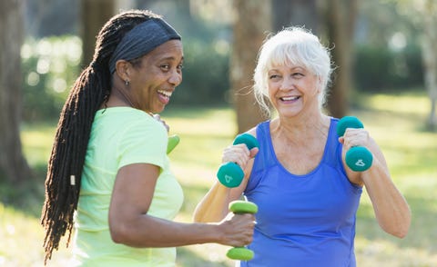 Two senior women exercising in park with hand weights Two senior women exercising in park with hand weights