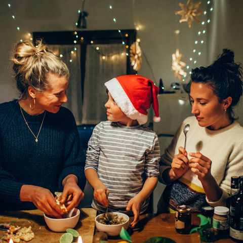 two women preparing christmas dinner with young boy