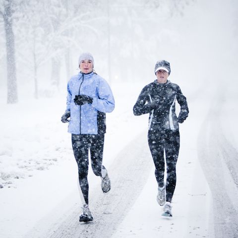 two women run down mountain avenue in a snowstorm