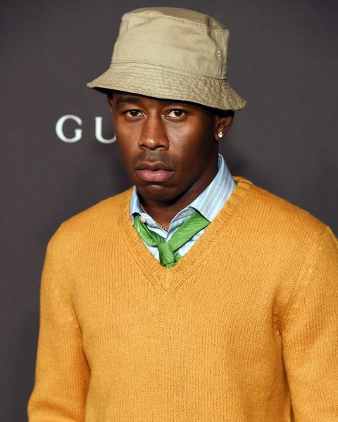 tyler the creator, wearing an orange gucci sweater with a blue button up and green tie and a tan bucket hat, attends the 2019 lacma art  film gala red carpet