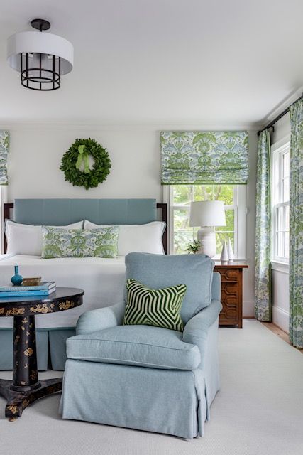 a blue bedroom with a wreath hanging above the bed