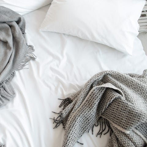 Unmade bed with pillow and gray blankets top view Unmade bed with pillow and gray blankets top view