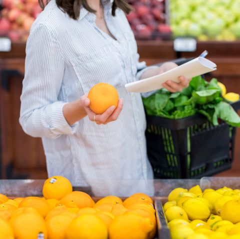 Unrecognizable woman shops for oranges