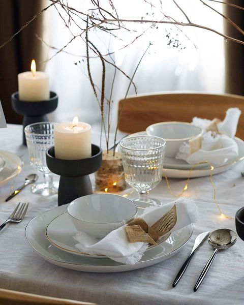 mesa de navidad con vajilla blanca y dorada