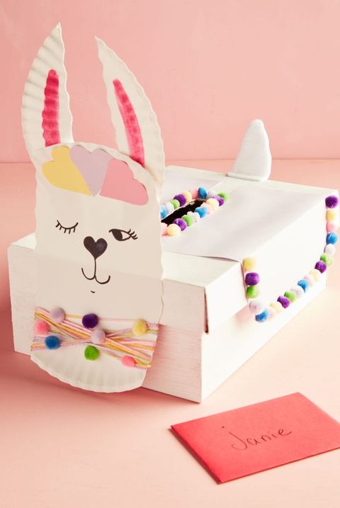 llama valentine box idea with paper plate face, decorated with colorful mini pom poms, yarn, paper cutouts, and markers