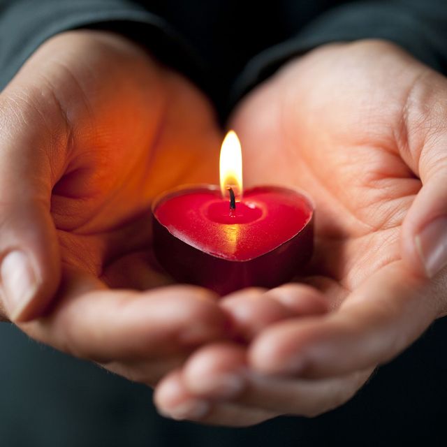 hands holding heart shaped candle