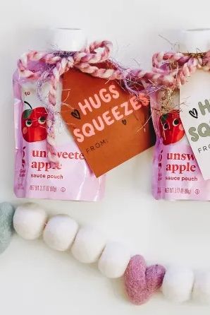 applesauce kids snack touches with valentine cards tied on with yard that say hugs and squeezes