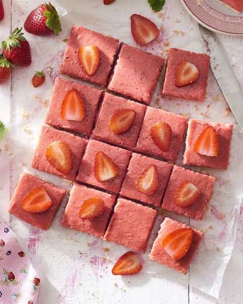 strawberry rhubarb shortbread bars each topped with a slice of strawberry