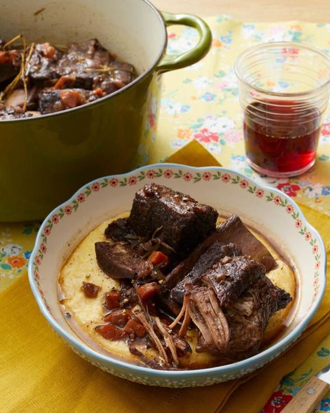braised short ribs in bowl with polenta and glass of wine