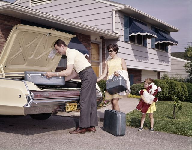 1960s 1970s family couple with little daughter holding big teddy bear loading luggage into automobile trunk for vacation  photo by h armstrong robertsclassicstockgetty images
